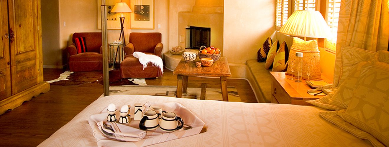 A guest room at the Inn of the Anasazi — warm adobe walls, a corner fireplace and handcrafted Southwestern furnishings.