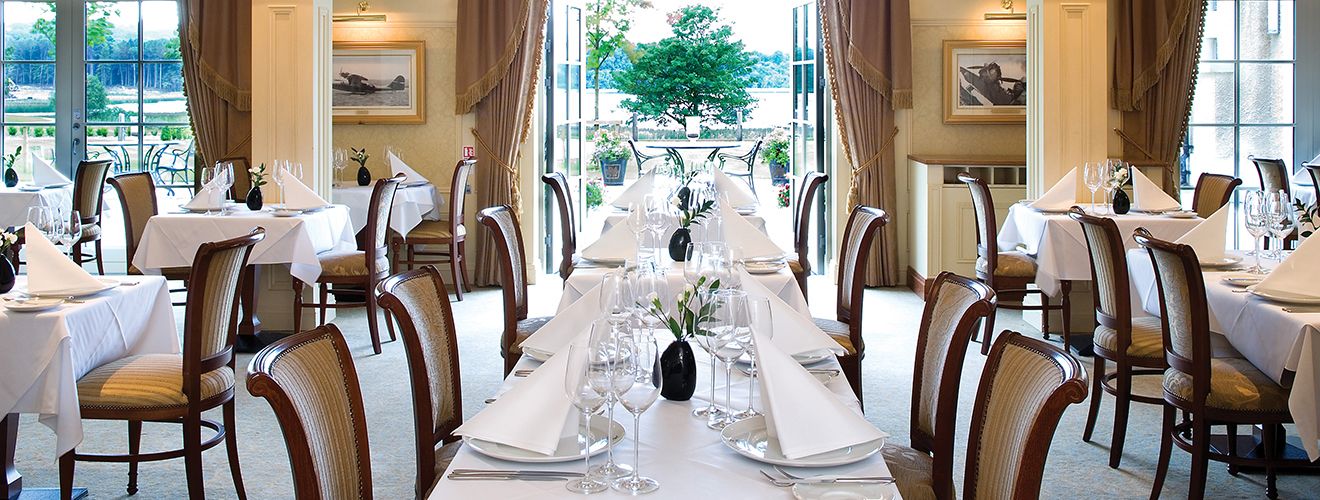 Catalina, the lakeside fine-dining room at Lough Erne Resort — white linens and open doors to the Fermanagh lake.